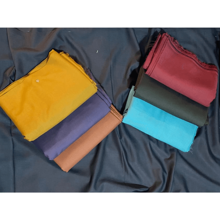 Folded men's unstitched suiting fabrics in mustard, purple, rust, maroon, olive and turquoise dark shades